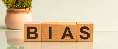 BIAS sözcüğü, arka planda bir çiçekle küp bloklardaki ahşap bir masanın üzerinde.
