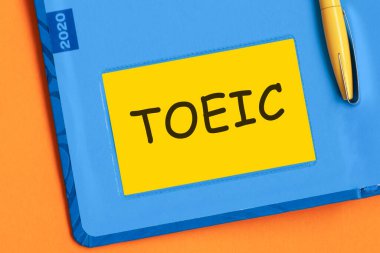 Ayak parmağı kelimesi sarı not kağıdına siyah harflerle yazılır. Mavi günlüğün arka planında sarı bir kalem gömülü..