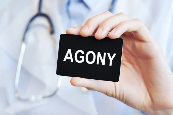 doctor holding a paper card with text agony, medical concept