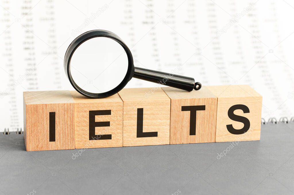 On wooden blocks under a magnifying glass text: ielts. Educational concept. IELTS - words from wooden blocks with letters, International English Language Testing System IELTS exam concept