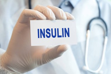 Doktorun elinde içinde INSULIN yazan beyaz bir kağıt var. Tıbbi konsept. Tıp doktorunun elindeki INSULIN kartı