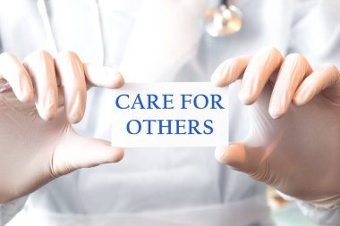 Doktor iki elinde de diğerleri için mesaj kutusu olan bir kart tutuyor. Tıbbi konsept,