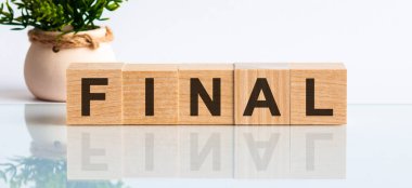 Tahta bloklar ile metin: son. Metin siyah harflerle yazılır ve masanın ayna yüzeyine yansıtılır.