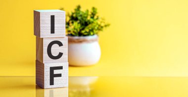 ICF - Uluslararası Teknik Direktör Federasyonu - kavram, alfabe ile küp tahta blok kısaltması ICF. Parlak Sarı arkaplan.