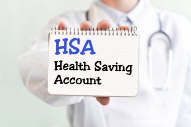 HSA-Sağlık Tasarruf Hesabı, tıbbi konsept yazılı bir kart tutan doktor. Metin tıbbi bir dergide mavi harflerle yazılmış..