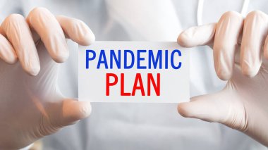 Doktor iki elinde de PANDEMIC Planı yazılı bir kart tutuyor, tıbbi konsept.