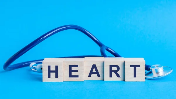 Herzwort Geschrieben Auf Holzklötzen Und Stethoskop Auf Hellblauem Hintergrund Versicherungs — Stockfoto