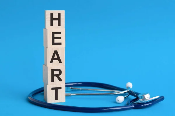 Herzwort Geschrieben Auf Holzklötzen Und Stethoskop Auf Hellblauem Hintergrund Versicherungs — Stockfoto