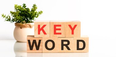 Tahta blokta yazan anahtar kelime. Faks metni masada, konsept. Arama motoru optimizasyonu, Faqs metin tablosu, konsept. Kırmızı harf anahtarı..