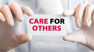 Doktor iki elinde de diğerleri için mesaj kutusu olan bir kart tutuyor. Tıbbi konsept. Hastane, klinik ve tıbbi otobüsler için sağlık hizmetleri kavramı.