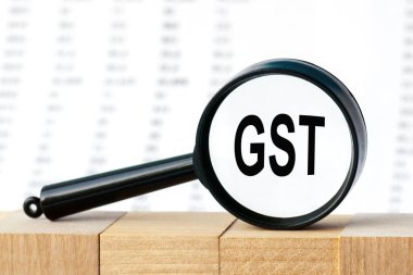 GST sözcüğüne büyüteçle bakmak, bir iş kavramı. Sayılar sütununun arka planında büyüteç. GST - Mal ve Hizmetler Vergisi