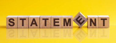 Tahta bloğa yazılmış bir ifade. Kelime, sarı masanın üzerinde duran ahşap yapı taşlarından yapılmıştır. iş konsepti, sarı arkaplan