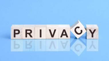 Tahta küp blokta metin gizliliği, hisse senedi konsepti. Metin mahremiyeti küplere siyah harflerle yazılır. Küpler mavi cam bir yüzey üzerindedir..