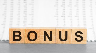 Tahta bloğa yazılmış bonus kelime rakamların arka planında. Tahta masa üzerinde bonus metin desing için, konsept