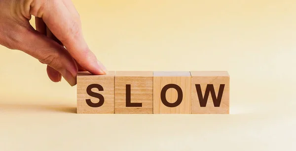슬로우라는 단어의 알파벳 큐브를 놓습니다 단어는 테이블의 노란색 입방체 쓰여져 — 스톡 사진