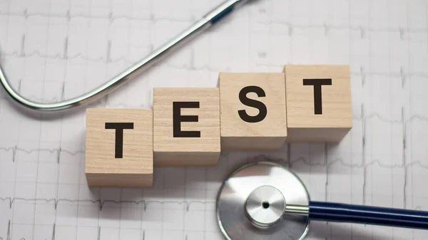 Test word written on wooden blocks and stethoscope on light background. Healthcare conceptual for hospital, clinic and medical busines.