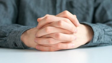 Masanın üzerinde, kilit altında erkeklerin güçlü elleri, güven konsepti, sakinlik, koruma ve güç, genç adamın elleri.