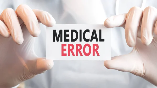 Doctor holding a card with text MEDICAL ERROR in both hands. Medical concept