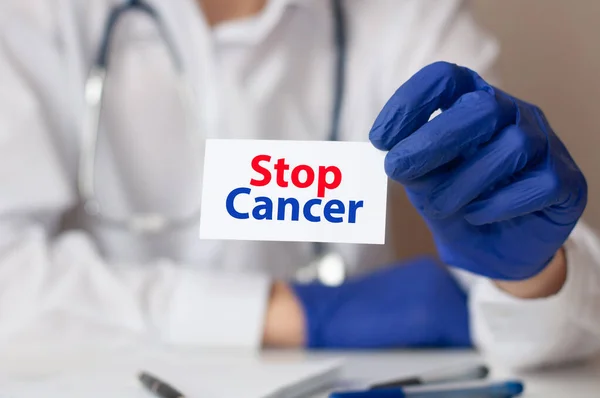 Doctor holding a white paper card with text Stop Cancer, medical concept. Healthcare conceptual for hospital, clinic and medical busines.
