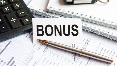 Bonus 'u gösteren metin yazılıyor. Beyaz kart, siyah harf, beyaz arka plan üzerine metin bonusu yazmak. İş konsepti.