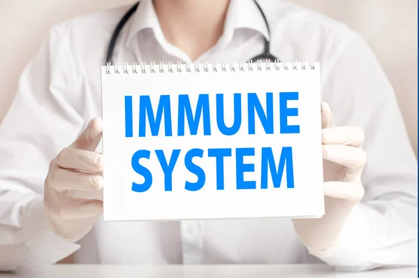 Doctor showing a card with text IMMUNE SYSTEM, medicine concept