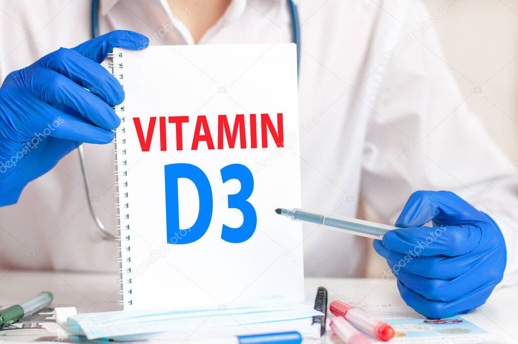 Doctor holding card in hands and pointing the word VITAMIN D3. Medical concept.