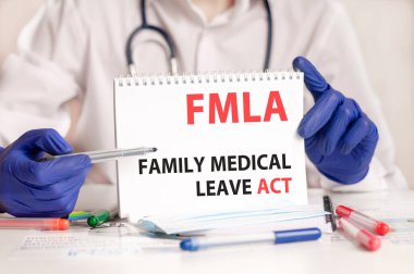 FMLA card in hands of medical Doctor. Doctor's hands in blue gloves holding a sheet of paper with text FMLA - short for Family Medical Leave Act, medical concept. clipart