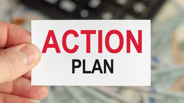 Motivational words: ACTION PLAN. Man holds a piece of paper with the text: ACTION PLAN. Business and finance concept