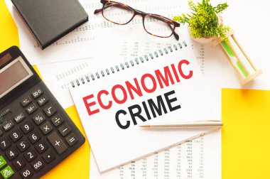 EKONOMİK CRIME 'i gösteren metin yazılıyor. Beyaz kağıt üzerine ECONOMIC CRIME metni yazmak, kırmızı ve siyah harfler, sarı arkaplan. İş konsepti.