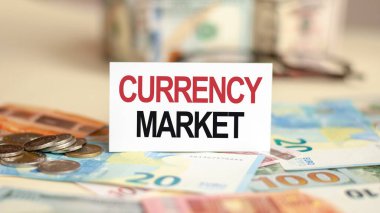 Finans ve ekonomi kavramı. Masanın üzerinde banknotlar, bir tomar dolar ve üzerine yazdığı bir tabela var - CURRENCY MARKET