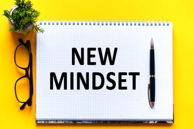 Kelime metni, beyaz kağıt, siyah harflerle yazılmış. Sarı arka planda kalem, bardak ve yeşil çiçek. İş konsepti. Eğitim kavramı.