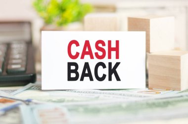 CASH sözcüğü, tahta küplerin yanındaki beyaz kağıt karta, hesap makinesine ve banknotlara yazılır. İş ve Finans kavramı