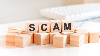 Ahşap bloklar ve madeni paralarla SCAM konsepti, iş konsepti