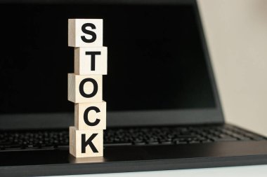 Kara zemine karşı bilgisayar klavyesinde tahta bloğa yazılmış hisse metni. İş ve Eğitim kavramı.