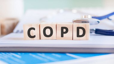 Copd kelimesi, kağıt bir arka planda steteskopun yanındaki tahta küplere yazılır. Tıbbi konsept. COPD - Kronik Engelleyici Akciğer Hastalığı
