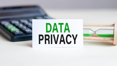 Arkaplanda DATA Özellikli beyaz kart, hesap makinesi ve kum saati var. İş ve ekonomi kavramı.