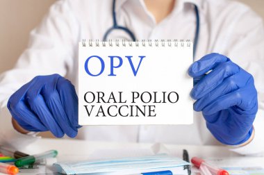 OPV kartı tıbbi doktorun elinde. Doktorun elleri mavi eldivenli elinde OPV yazılı bir kağıt tutuyordu. Oral çocuk felci aşısının kısaltılmışı, tıbbi konsept..