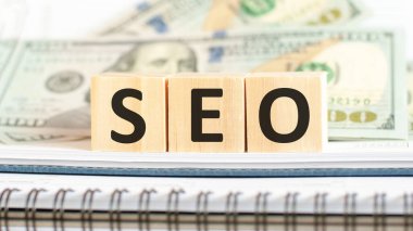 Evet. Arama Motorları İyimserleştirmesi 'nin kısaltılmışı. Tahta küpler ve dolar arkaplanı üzerine iş konsepti
