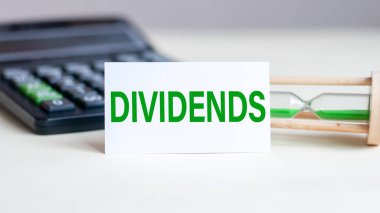 Beyaz kağıt kart, arka planda mesaj ayracı, hesap makinesi ve kum saati var. İş ve ekonomi kavramı.