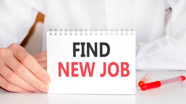 Masanın üzerinde kırmızı bir keçeli kalem ve üzerine yazılan beyaz bir tablet var - Yeni bir iş bul, kırmızı ve siyah harfler. İş konsepti.