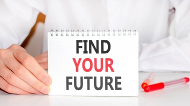On the table there is a red marker and a white paper tablet on which the text is written - FIND YOUR FUTURE, red and black letters. Business concept.