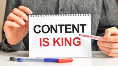 Masanın üzerinde kırmızı bir işaret ve beyaz kağıt bir tablet var. Metnin yazılı olduğu içerik kral, kırmızı ve siyah harflerdir. İş konsepti.