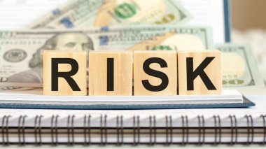 Kelime riski. Tahta küpler ve dolar arkaplanı üzerine iş konsepti