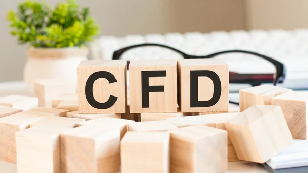 letters cfd cube wood on wooden table white background, business concept. CFD short for Contract For Difference