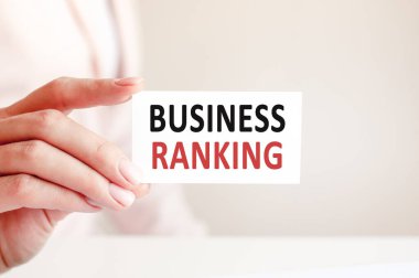 İş sıralaması bir kadının elindeki beyaz kartvizitle yazılır. Pembe arka plan. İş ve reklam kavramı