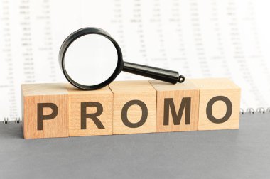 Tahta bloklar, büyüteçli tanıtım yazıları. Ahşap bloklar inşa etmek için kullanılan tanıtım kelimesi. İş, pazarlama ve eğitim konsepti için kullanılabilir.