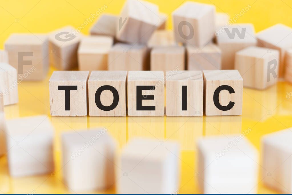 the word toeic is written on a wooden cubes structure. Blocks on a bright background. financial concept. selective focus. toeic short for test of english for international communication