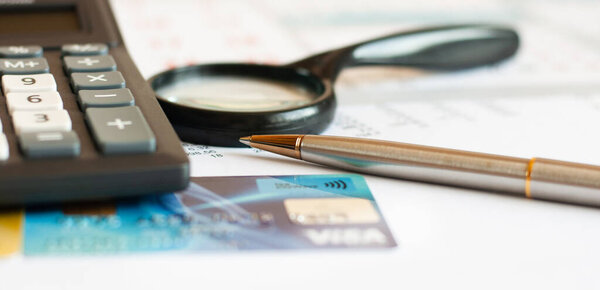 debt free from credit card concept background with calculator and magnifier on desk, close up, business concept