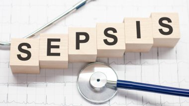 SEPSIS sözcüğü tahta bloklara ve steteskop açık beyaz arkaplana yazıldı