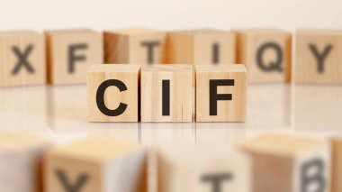 Masada üzerinde CIF harfleri olan üç oyuncak tahta blok, seçici odaklı. CIF - maliyet sigortası ve taşımacılığın kısaltması